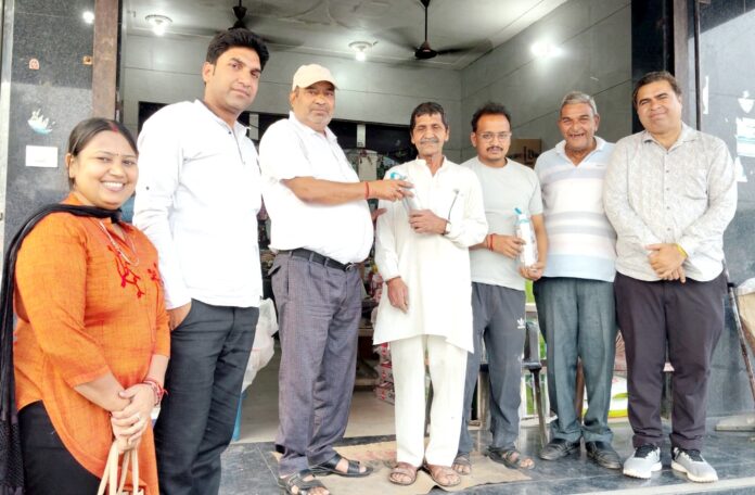 श्रमिकों को बोतल बांटते हुए संस्था के पदाधिकारीगण