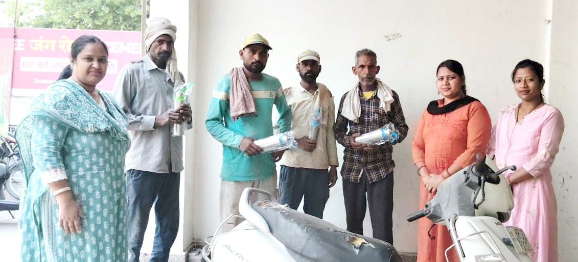 श्रमिकों को बोतल बांटते हुए संस्था के पदाधिकारीगण